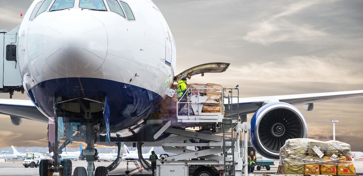 freight being loaded into an airplane for international shipping